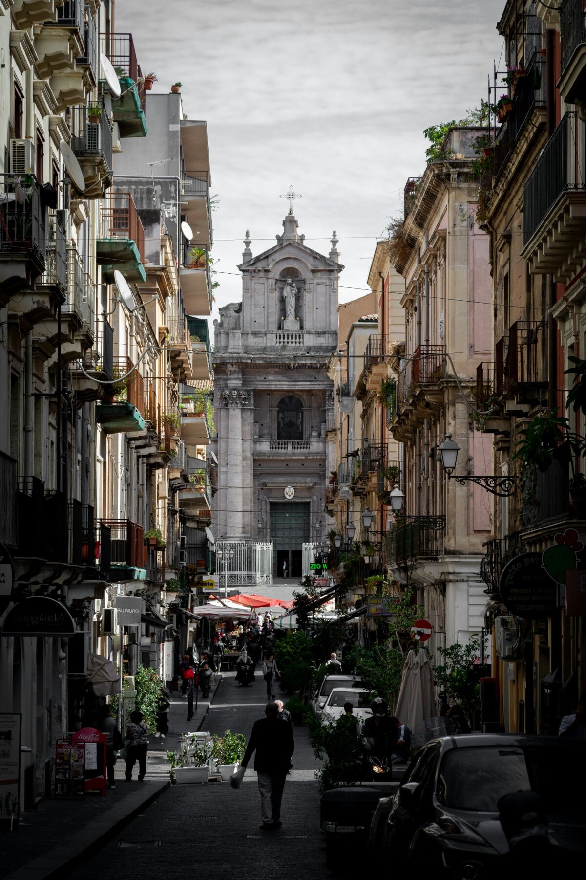 A narrow Catania street leading towards a baroque church façade