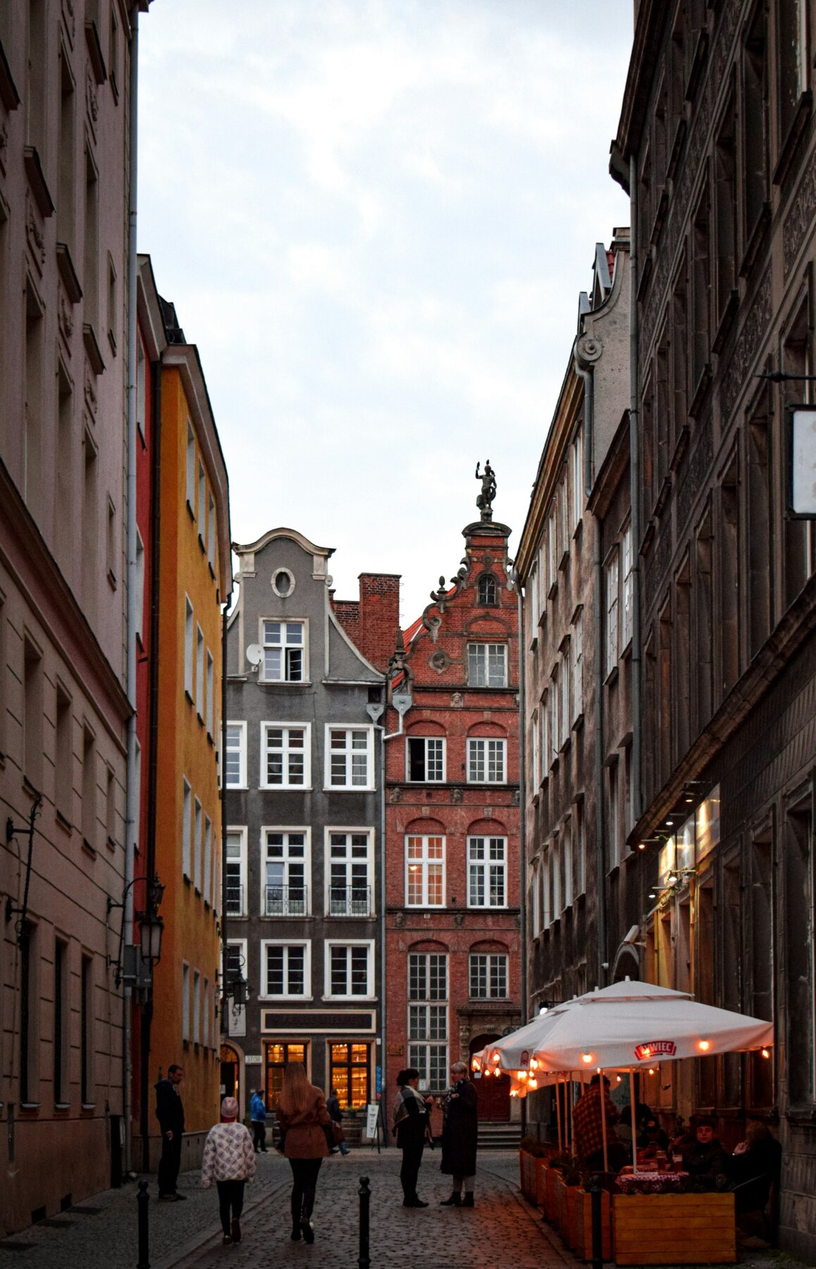 Pedestrians and colourful façades on an intimate lane in Gdańsk