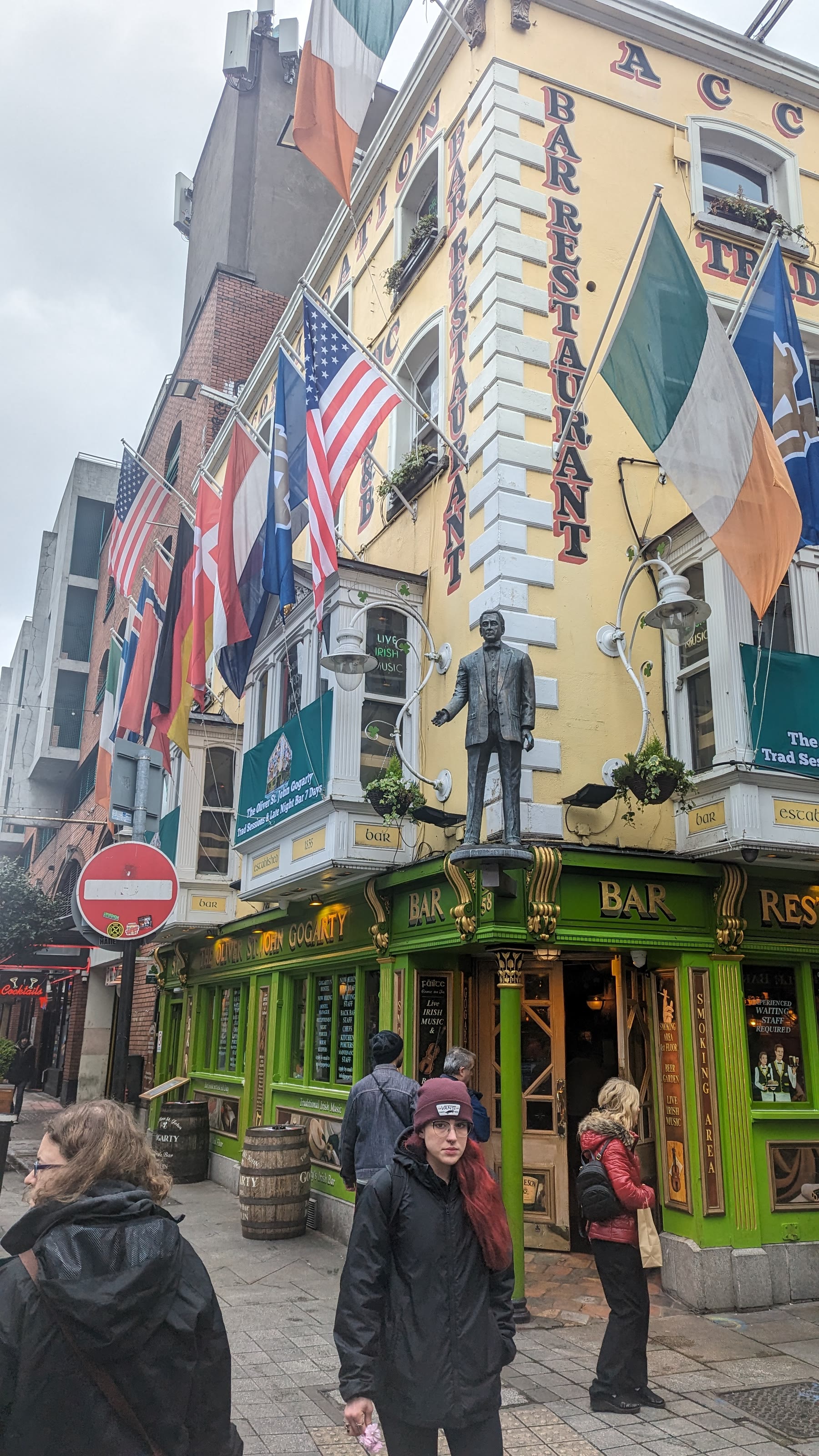 People outside a colourful traditional pub in central Dublin