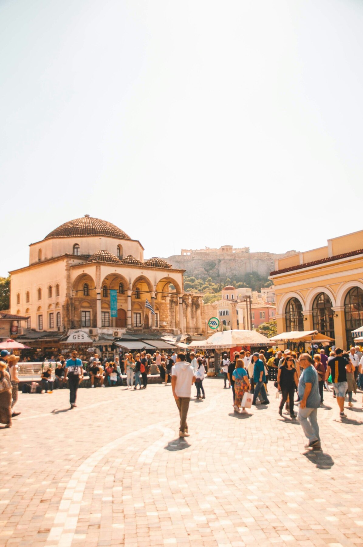 People crossing Monastiraki Square beside the historic mosque in Athens