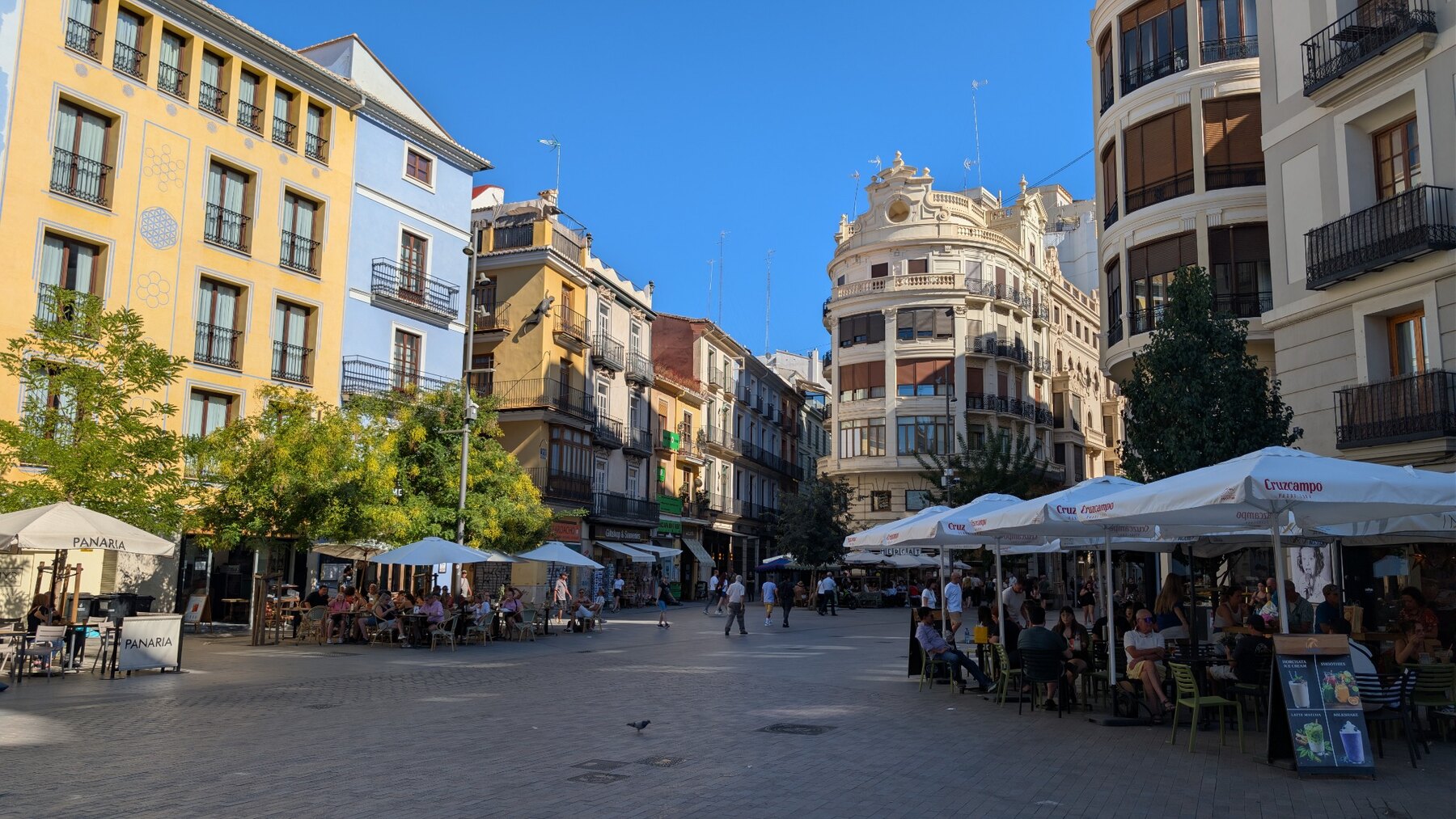 Cafés and pedestrians in a sunny Valencia neighbourhood square