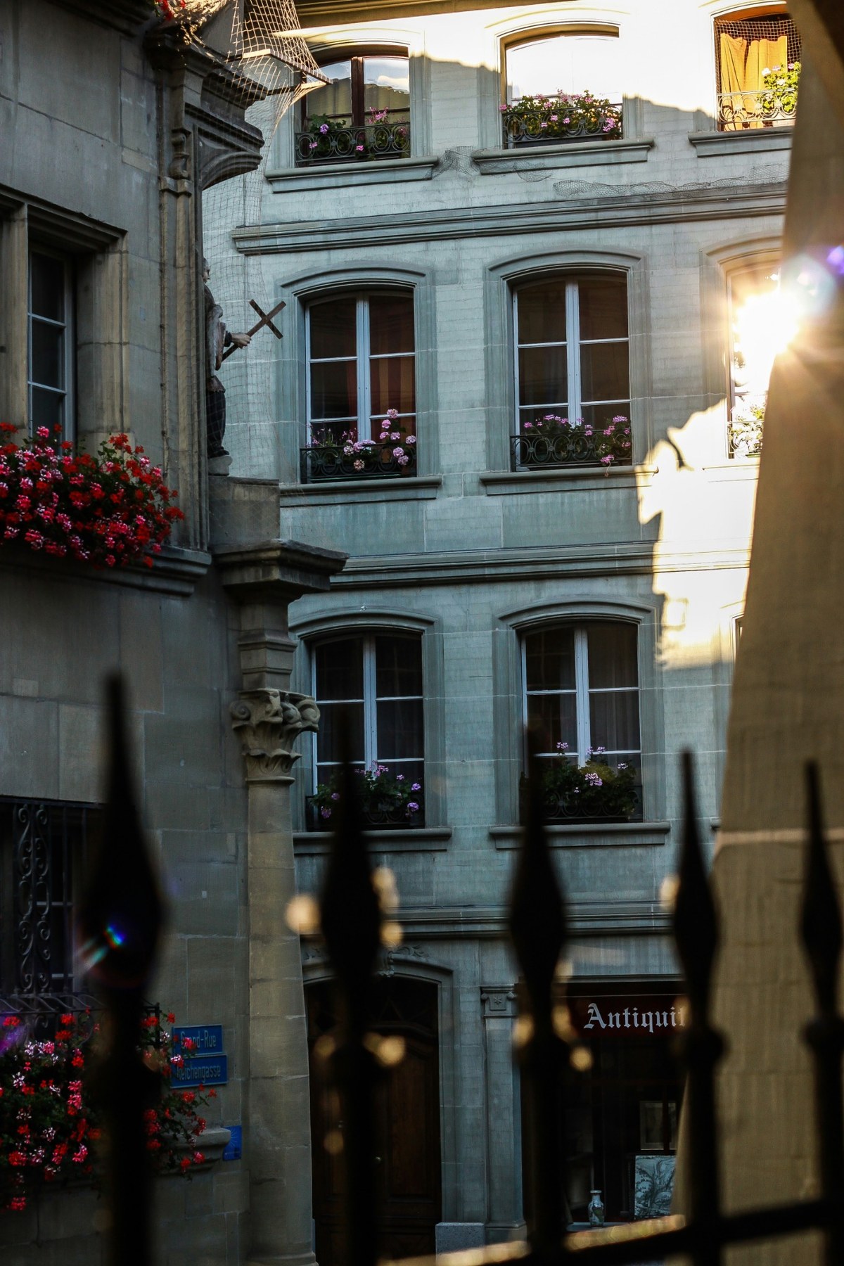 A narrow street lined with historic façades in Fribourg's old town.