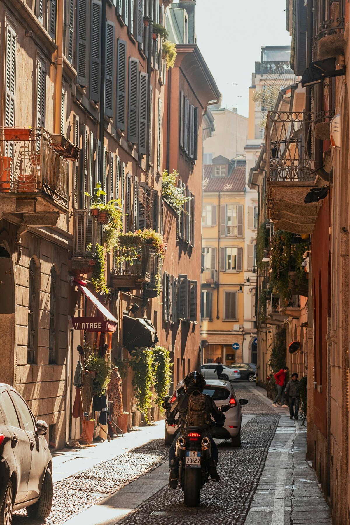 Scooter and balconies on a narrow residential street in Milan