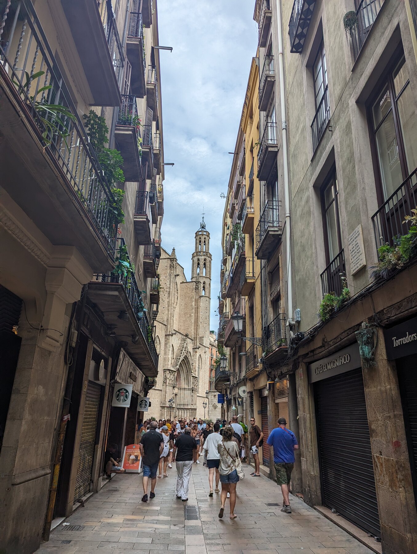 Pedestrians in a narrow stone street in Barcelona's historic centre