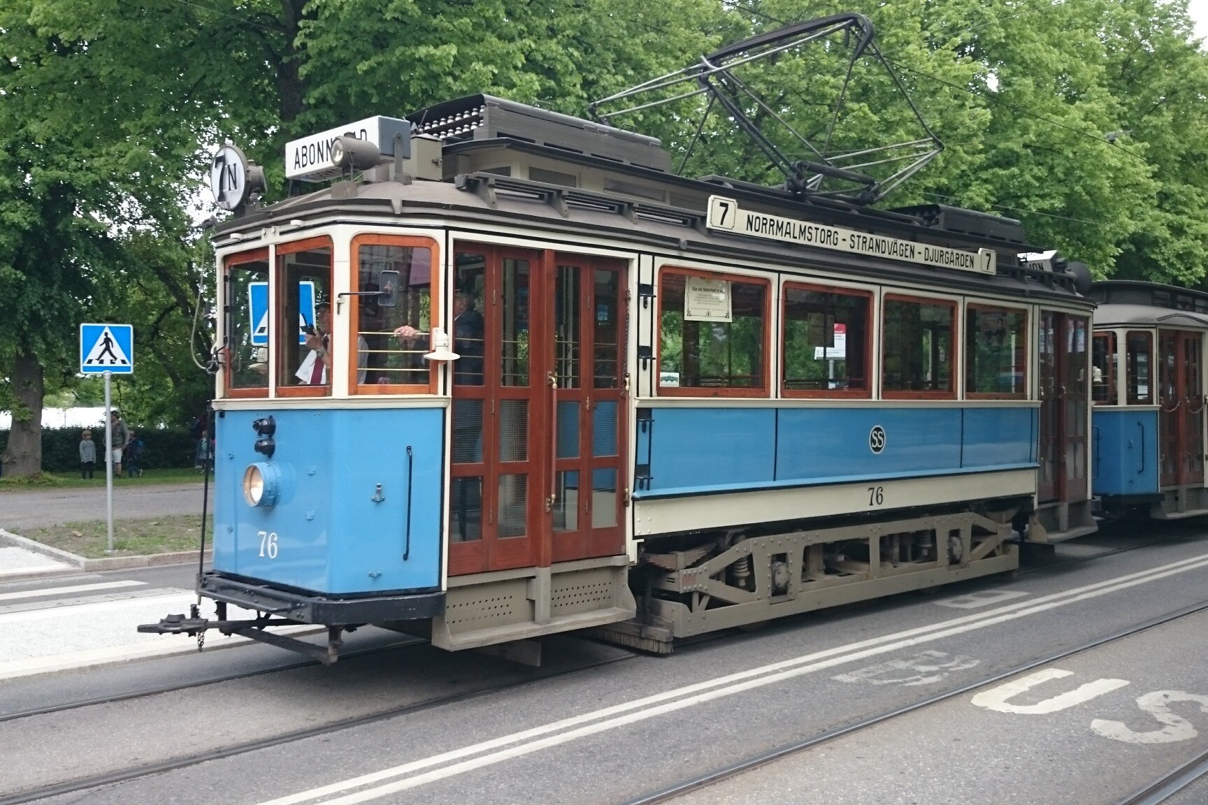 A historic blue tram travelling through Stockholm