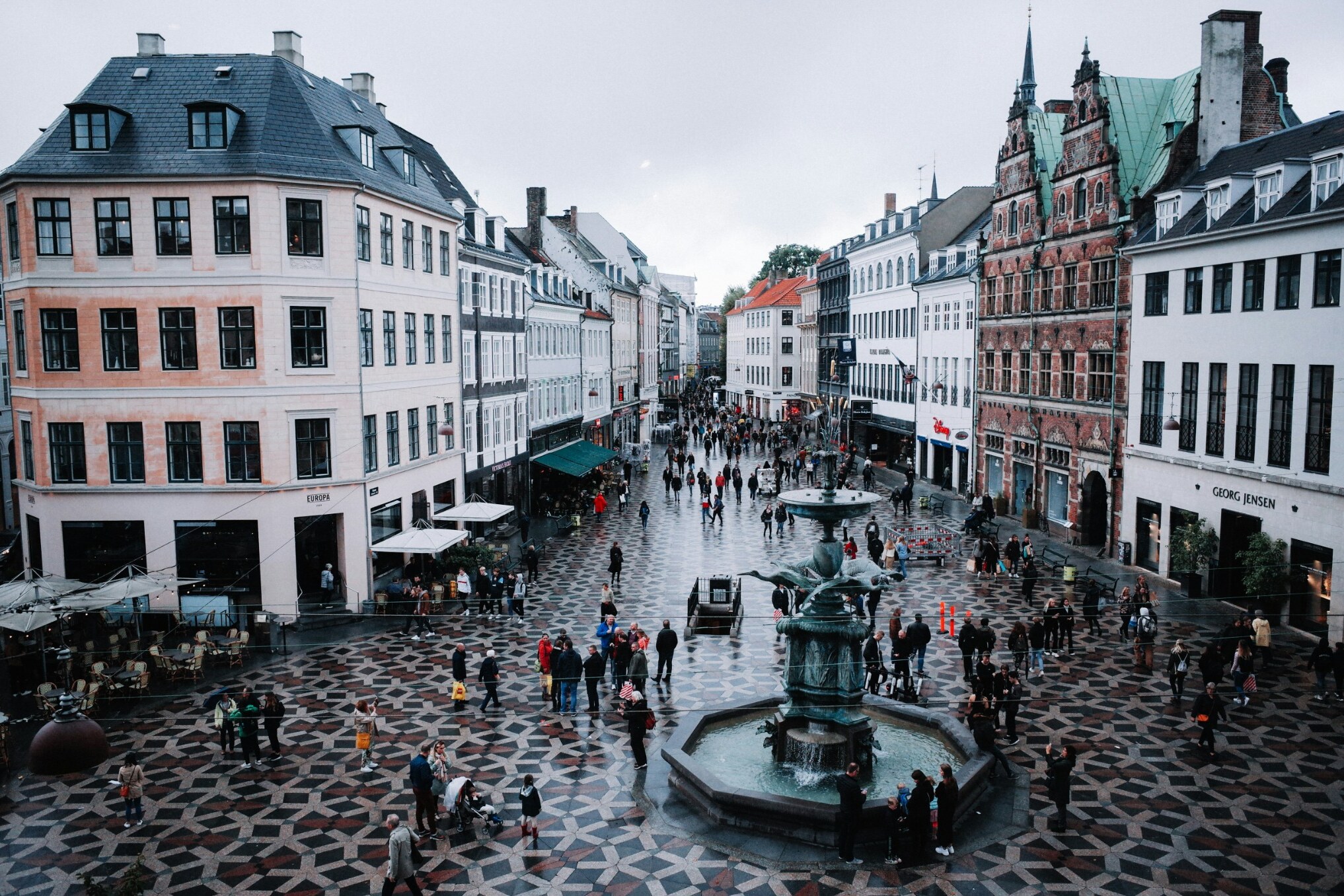 A rain-wet Copenhagen square surrounded by historic buildings