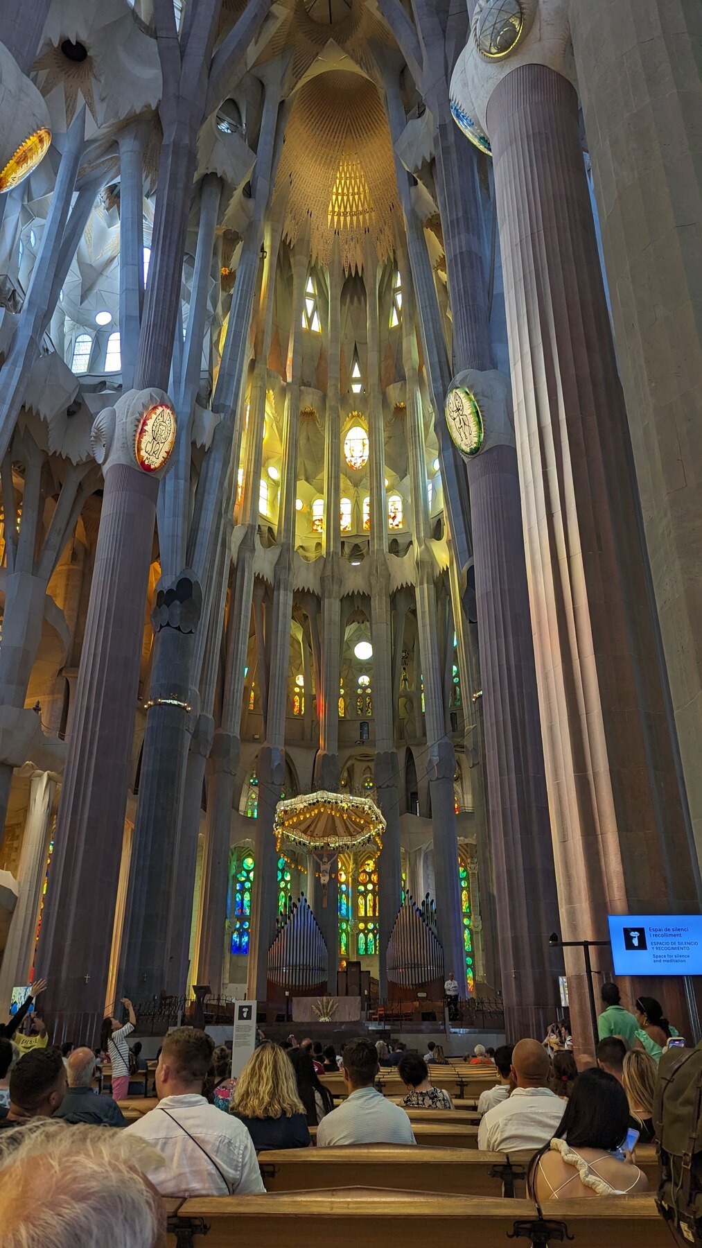 Visitors beneath the coloured light of the Sagrada Família interior