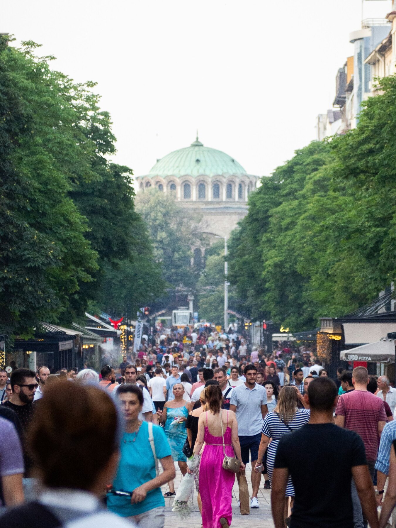Crowds walking along a tree-lined pedestrian boulevard in Sofia
