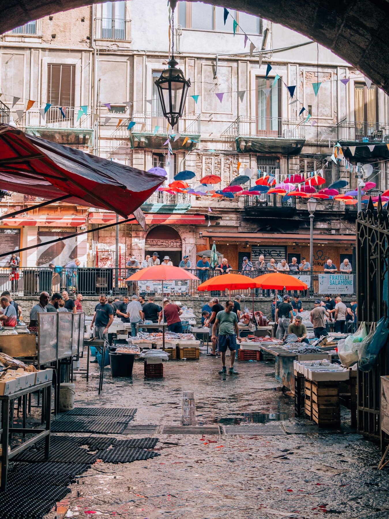 People and market stalls in Catania's working fish market