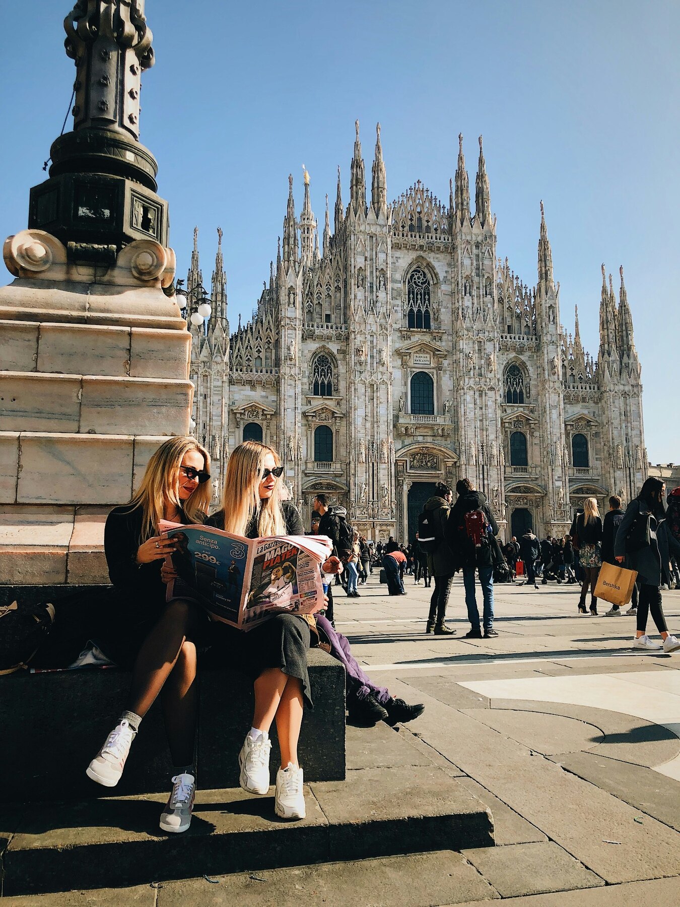 People sitting and walking in Piazza del Duomo in Milan