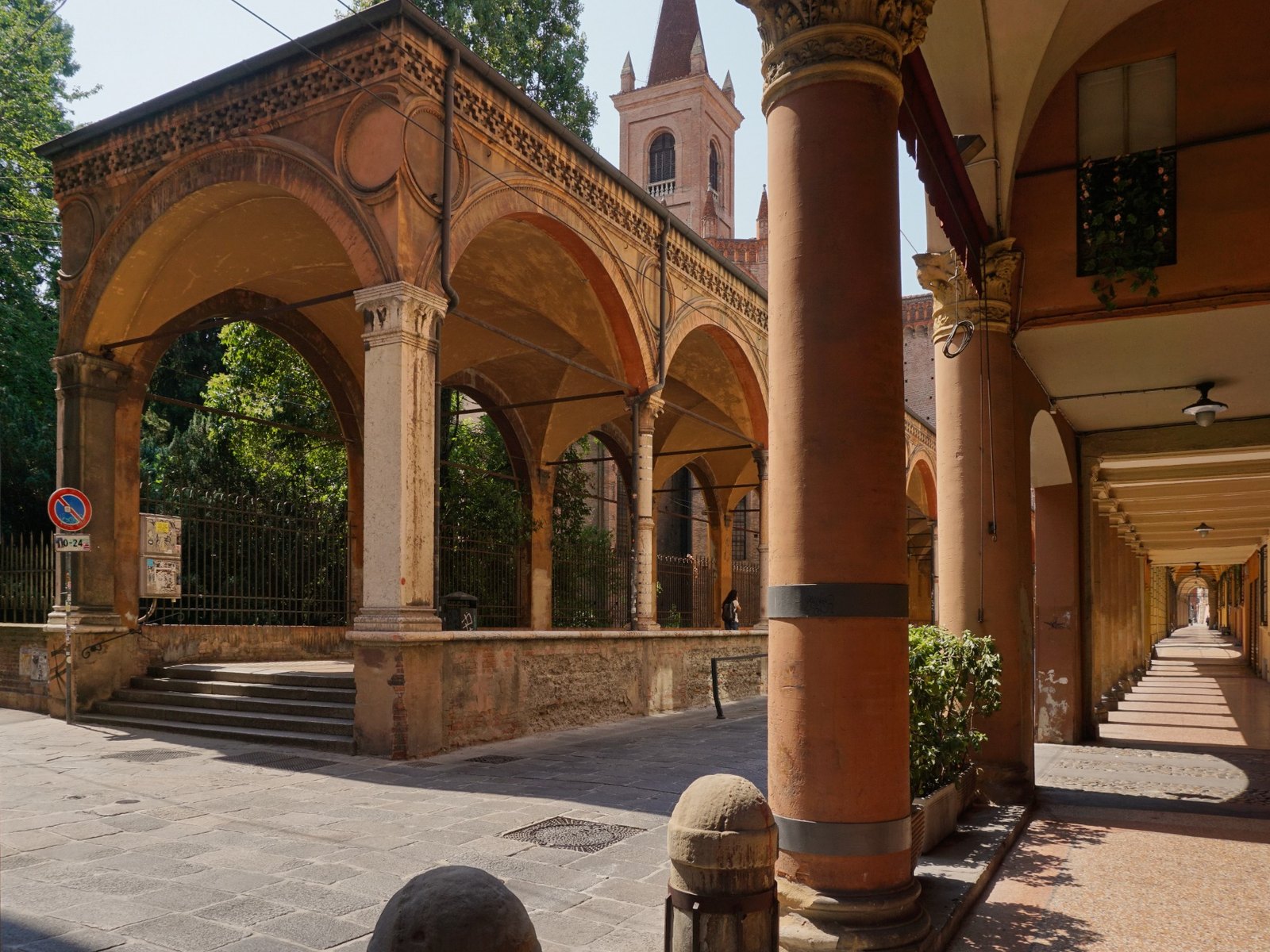 Historic porticoes along Strada Maggiore in Bologna, with warm brick arches and a long covered walkway.